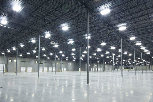 High bay lights suspended in a large manufacturing facility