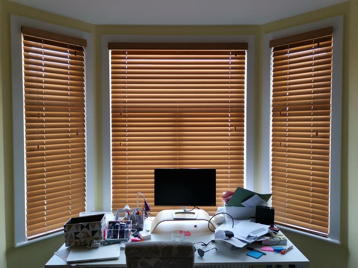 Office blinds curtains installer adjusting wooden blinds in a stylish workspace